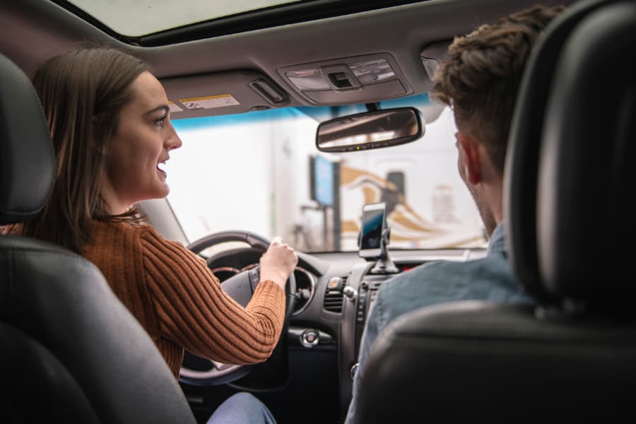 Woman driving car male passenger in front seat